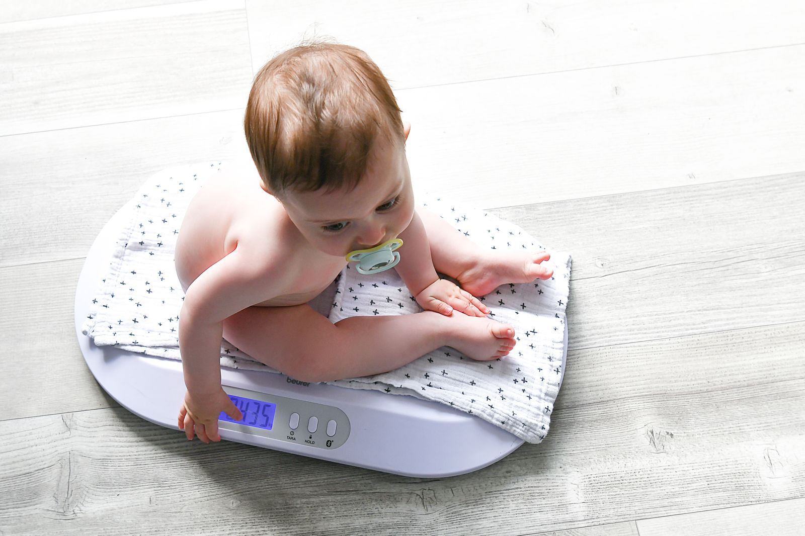 Een baby op de weegschaal tijdens de postnatale opvolging